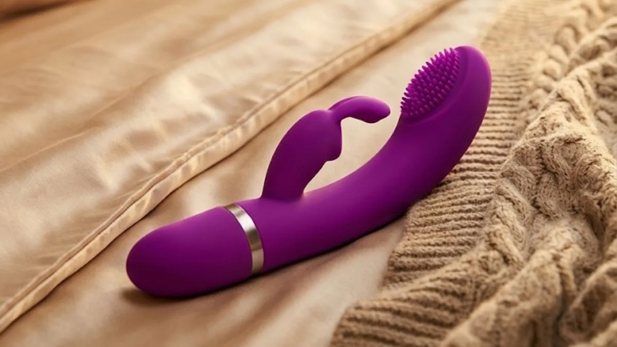 Vibrador rabbit de silicone rosa sobre superfície de mármore branco com iluminação suave